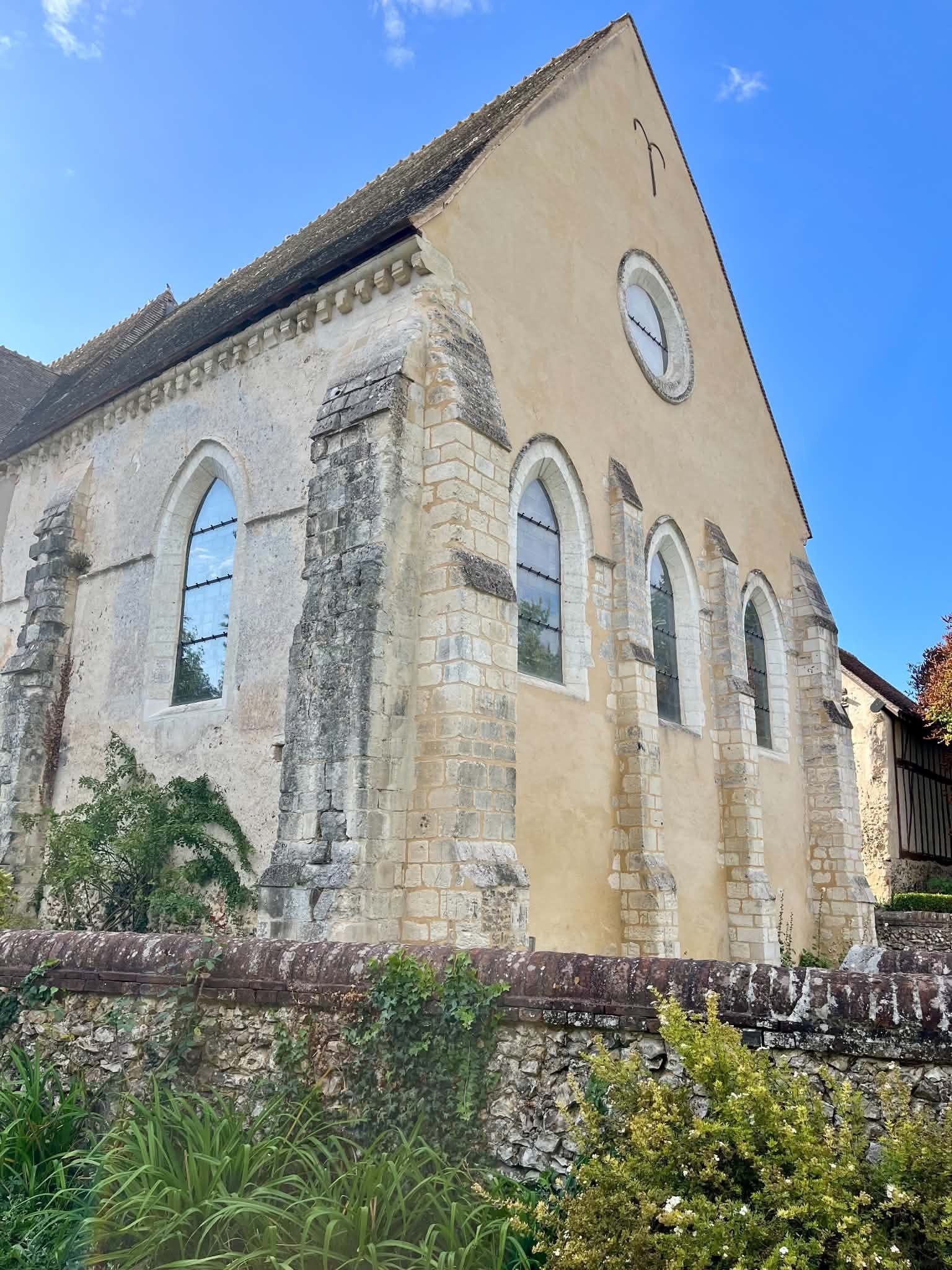 La façade sud de l’église de Muzy : trois baies en plein cintre, un oculus et des contreforts de brique