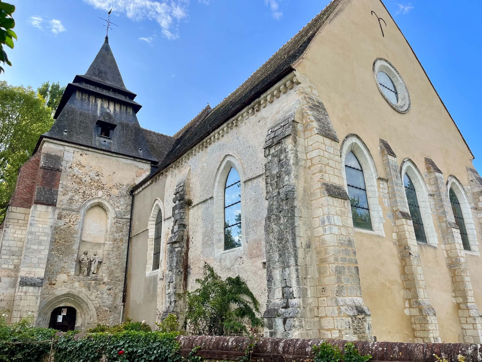 L’église Saint-Jean-Baptiste de Muzy : son clocher couvert d’ardoise surmonté d’une girouette, la nef et le pignon percé d’un oculus