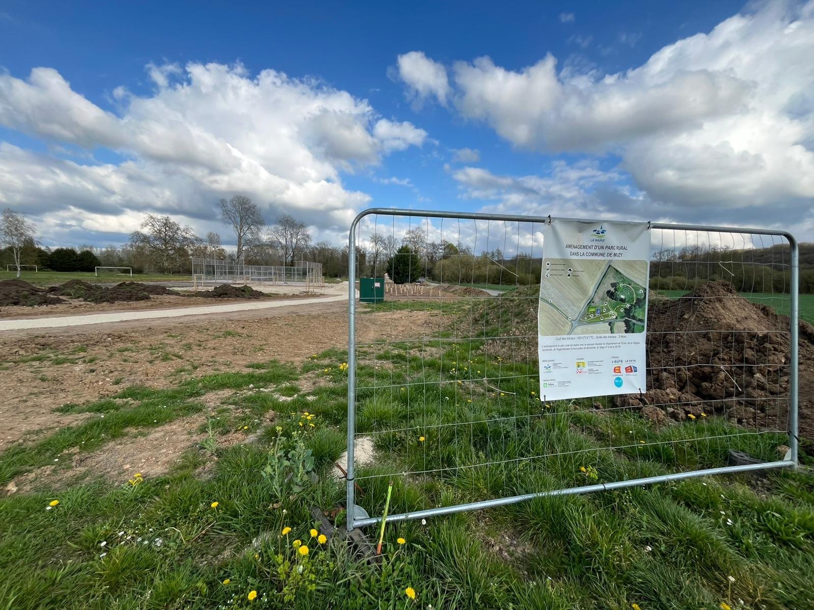 Le panneau du projet d’aménagement planté sur la parcelle communale de Muzy, encore en herbe